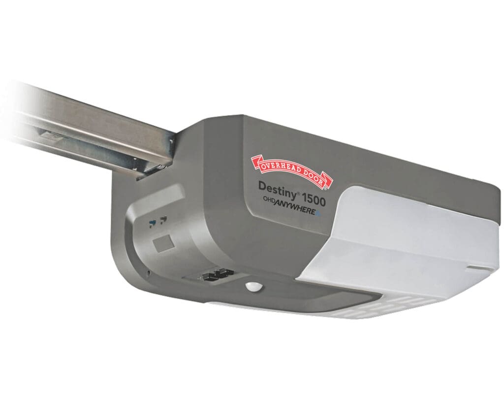 A gray Overhead Door Destiny 1500 garage door opener with a white LED panel is attached to a metal track; its side displays the brand and model name, and it’s compatible with a wireless keypad for convenient access.