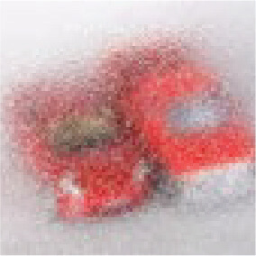 A blurry image of two red toy cars placed side by side on a light surface.