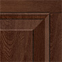 Close-up of a wooden cabinet door corner featuring a raised panel design and a rich brown finish, showcasing the wood grain and beveled edges.
