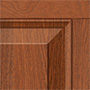 Close-up of a wooden cabinet door corner, showing a raised panel design with reddish-brown wood grain and a smooth, polished finish.