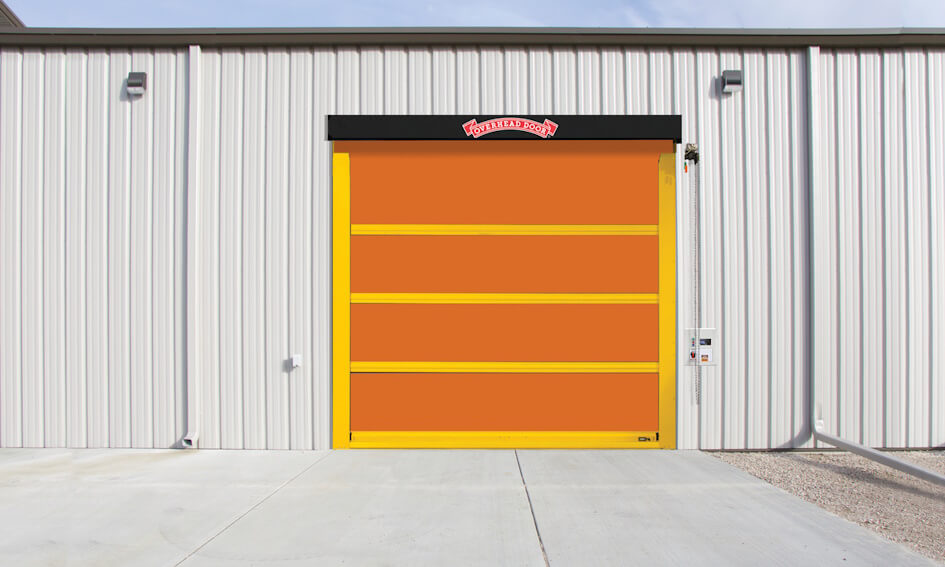 A large, orange high speed door with a yellow frame is set in a corrugated metal building. A small sign marked 993 is above the entrance, and a control panel is mounted on the wall to the right of this exterior fabric door.