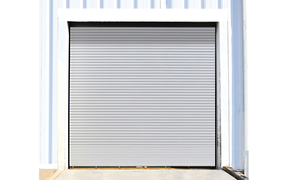 A closed gray Model 627 rolling steel service door set in a white frame on a corrugated metal building.
