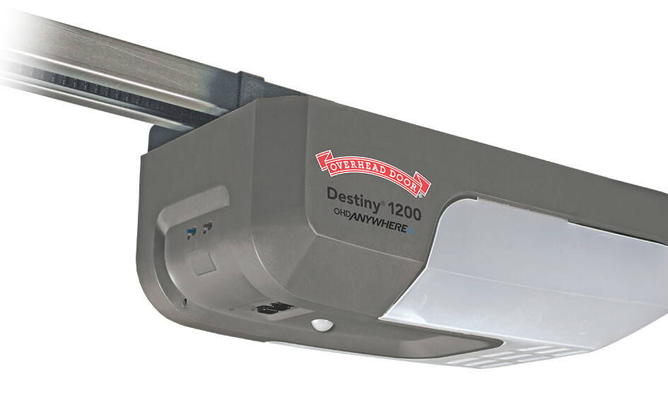 A close-up view of a Destiny 1200 garage door opener, featuring its gray housing, clear branding, and white light cover.