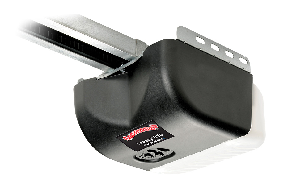 A black and white Legacy garage door opener labeled Legacy 850 is mounted to a metal rail, with a control button visible on the unit.