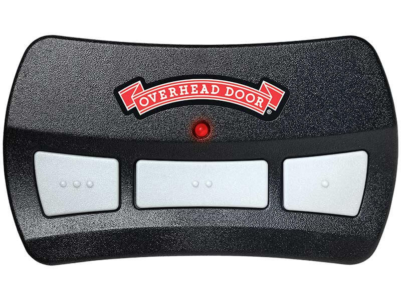 A black Overhead Door garage door remote with three white buttons and a red indicator light in the center, displaying the Overhead Door logo above the buttons.