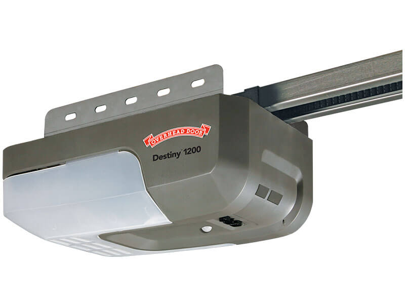 A gray Overhead Door Destiny 1200 garage door opener with a metal rail and LED light, shown attached to a ceiling mounting bracket.