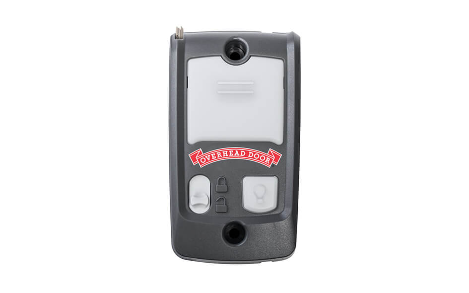 A black and gray wired wall console for garage door openers features the Overhead Door logo and two buttons below a rectangular light.